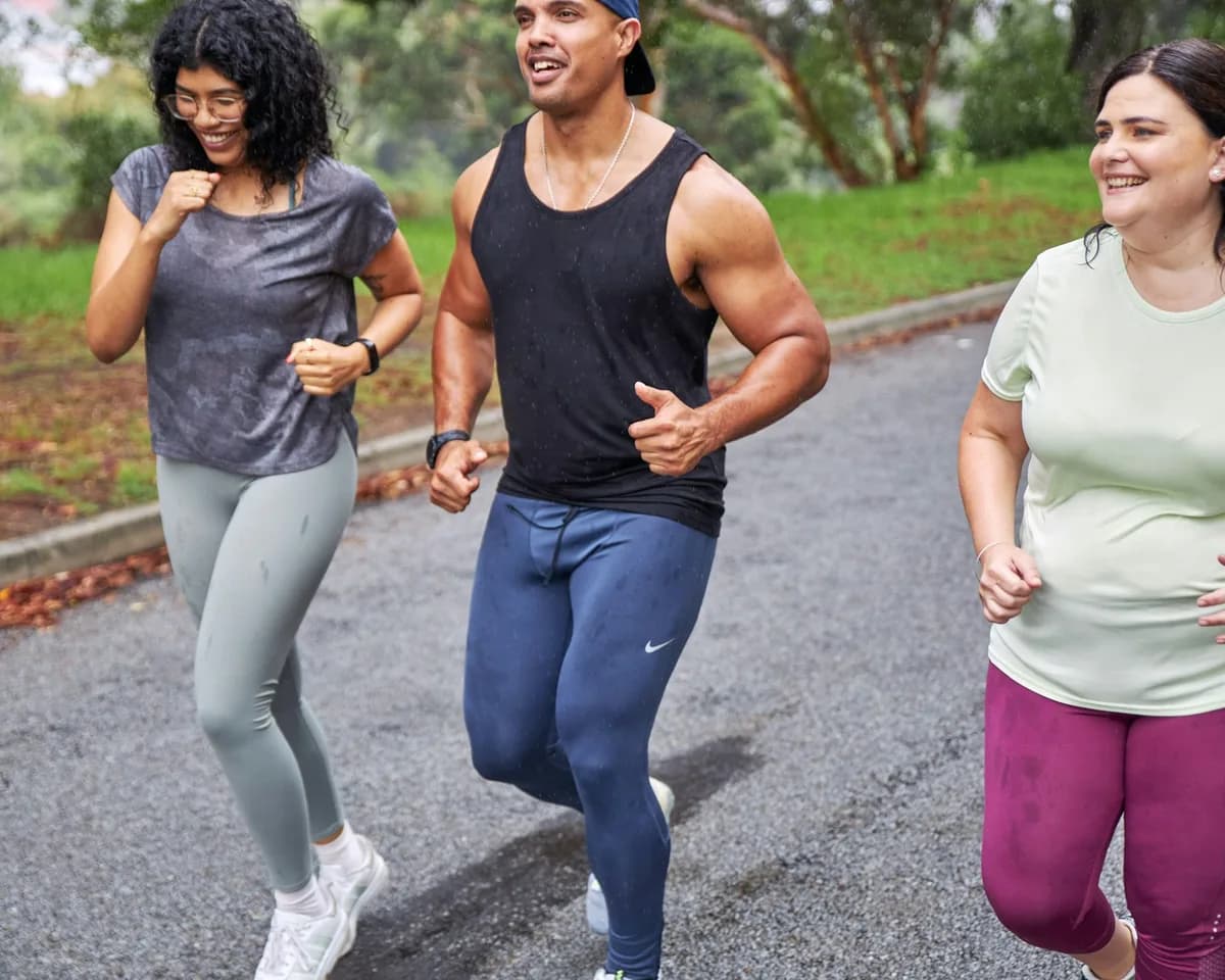 Three friends laughing as they go for a run together